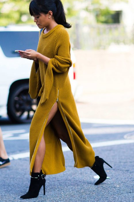 Menina caminhando com vestido amarelo para o frio