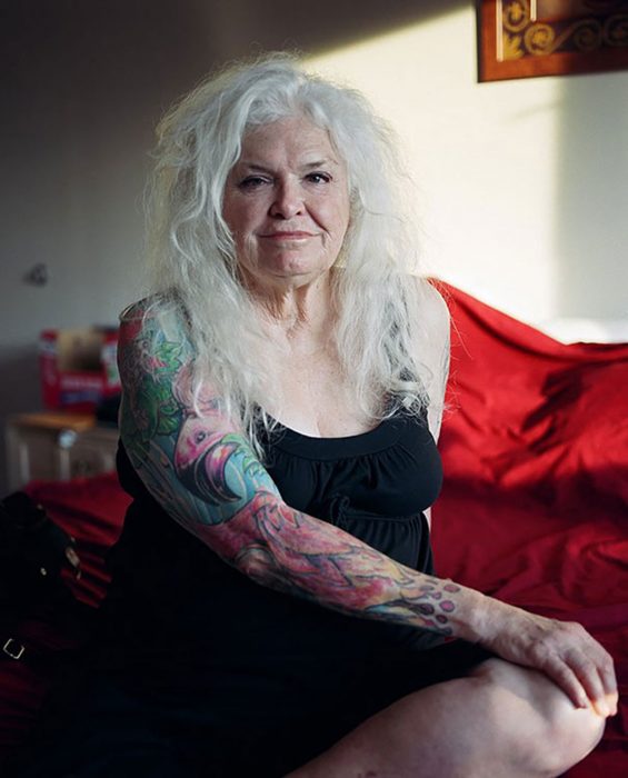 Senhora de cabelos longos e brancos com braço tatuado 