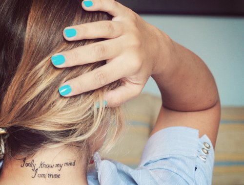 garota mostrando sua tatuagem de uma frase na nuca 