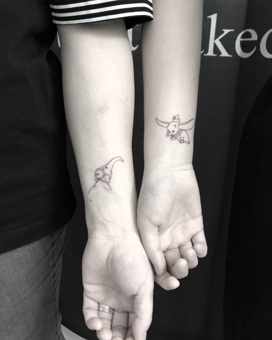 Tatuagem minimalista de Dumbo voando e sua mãe para casais ou amigos no antebraço