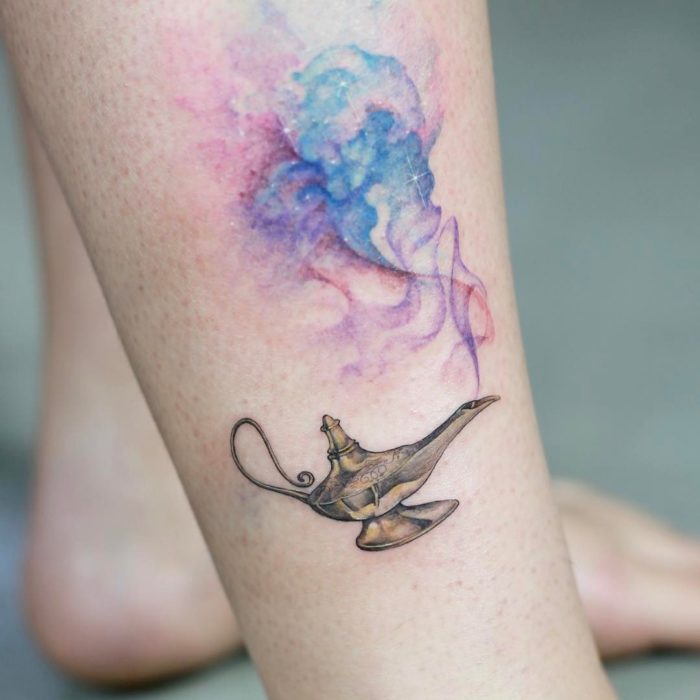 Tatuagem minimalista da lâmpada Disney Aladdin na perna