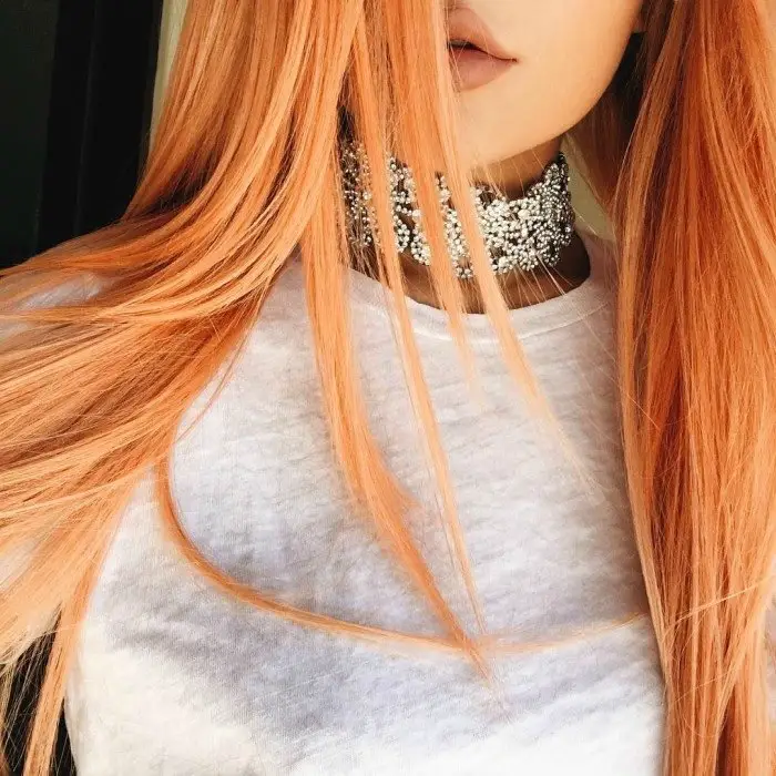 colar de mulher lábios castanhos e cabelo laranja 