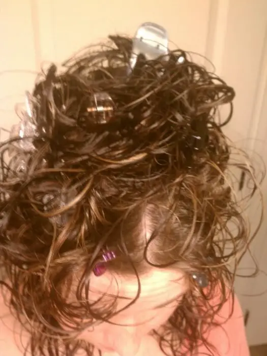 mulher com clipes de plástico no cabelo