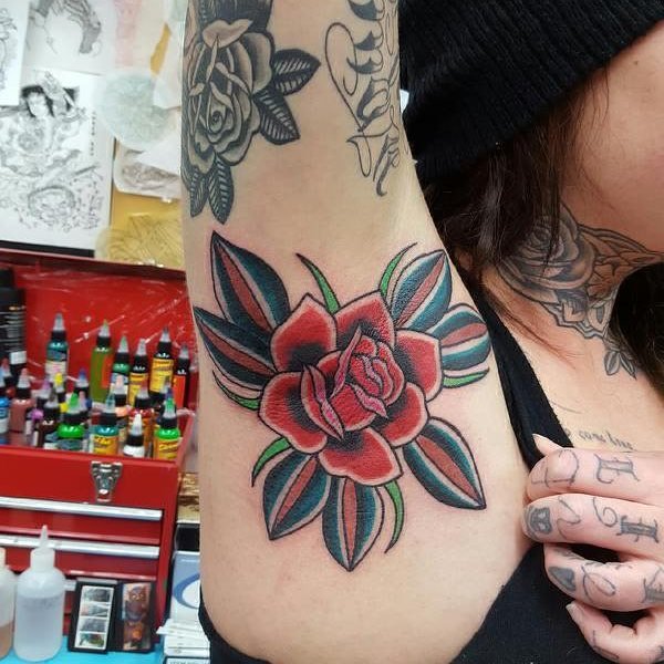 Menina com tatuagem na axila de uma flor 
