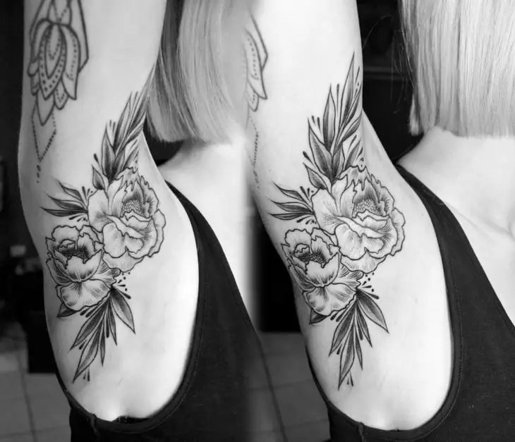 Menina com tatuagem na axila de uma flor 