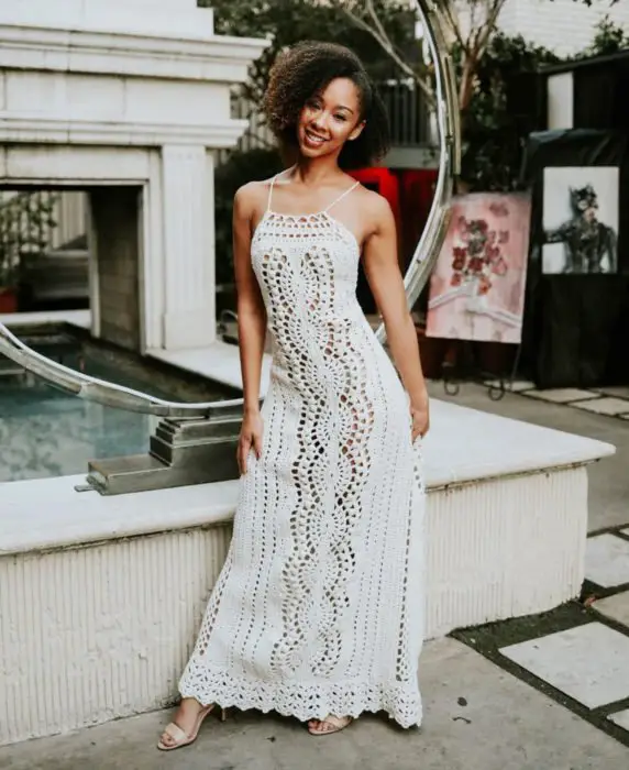 Mulher afro-americana com cabelo chinês e vestido longo de malha branca