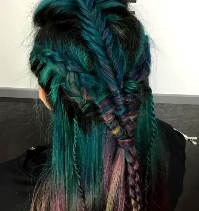 Menina com cabelo verde e roxo, com penteado estilo viking com tranças