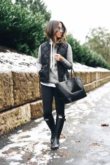 Rapariga com look com moletom, jeans e botas de chuva
