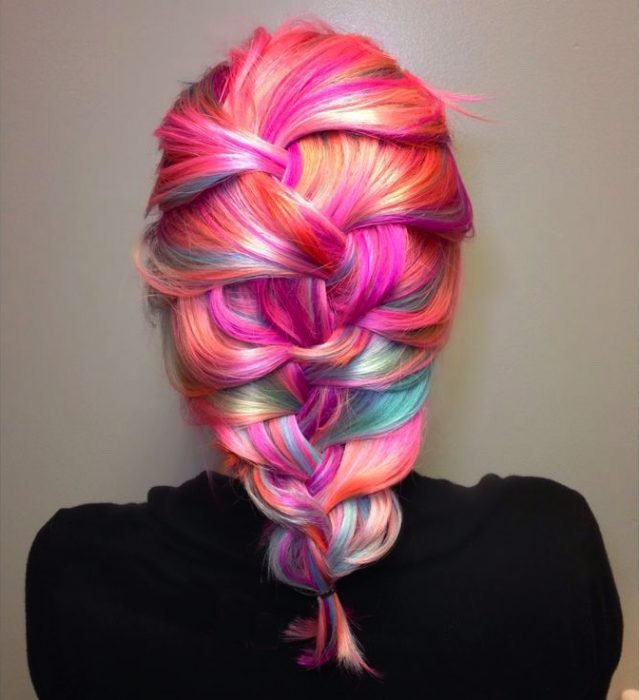 Menina com cabelo em diferentes tons de rosa preso em uma trança