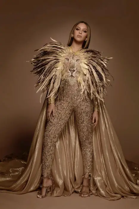 Beyoncé vestindo um terno com a cara de um leão na frente e uma longa capa nos ombros 