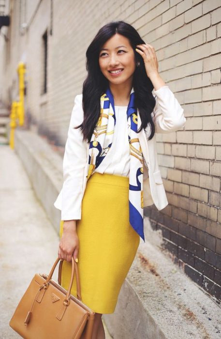 Menina vestindo um lenço com uma blusa branca e uma saia amarela 