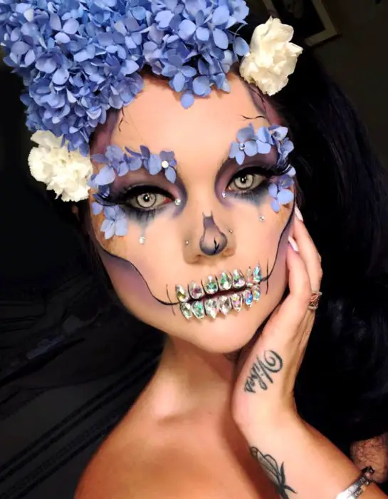 Maquiagem de Catrina Modern Day of the Dead com flores de hortênsia na cabeça e ao redor dos olhos