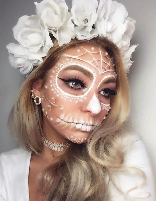 Maquiagem branca moderna do dia dos mortos Catrina;  menina loira com coroa de rosas brancas na cabeça