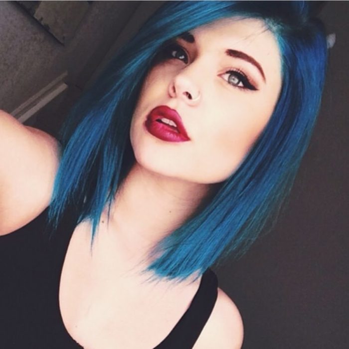 Garota tirando uma selfie para mostrar o cabelo curto em azul elétrico 