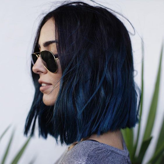 Menina com cabelo midi em tom azul, posando de perfil