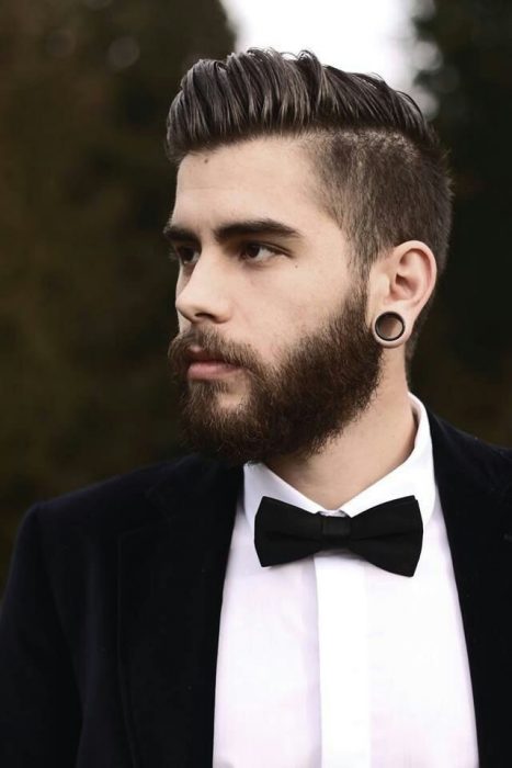 Homem com terno, barba, expansões e corte de cabelo elegante 