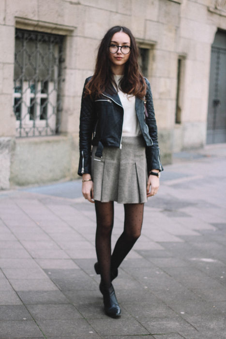 Menina vestindo uma saia cinza e uma jaqueta de pele 