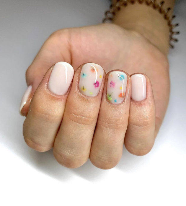 Desenhos de manicure para banhos de leite;  unhas curtas brancas com pequenas cores azul, amarelo, laranja, verde e rosa