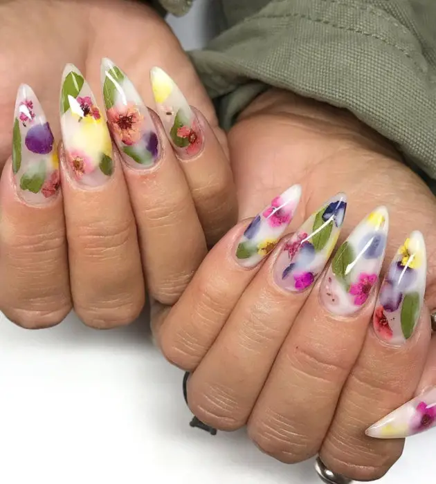 Desenhos de manicure para banhos de leite;  unhas longas brancas de estilete com flores roxas, rosa e azuis