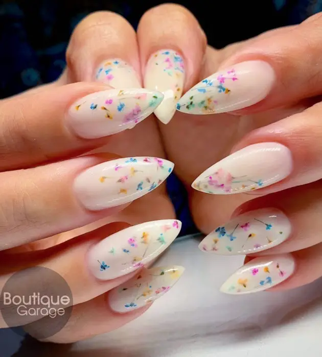 Desenhos de manicure para banhos de leite;  unhas longas brancas de estilete com flores rosa, amarelas e azuis
