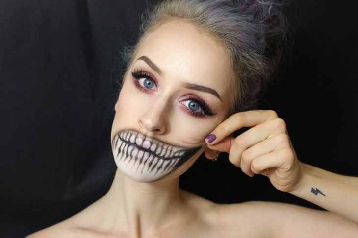 Menina com maquiagem para o halloween Com boca em formato de caveira 