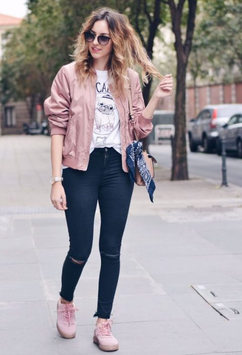 garota vestindo jeans, blusa estampada, tênis e jaqueta rosa