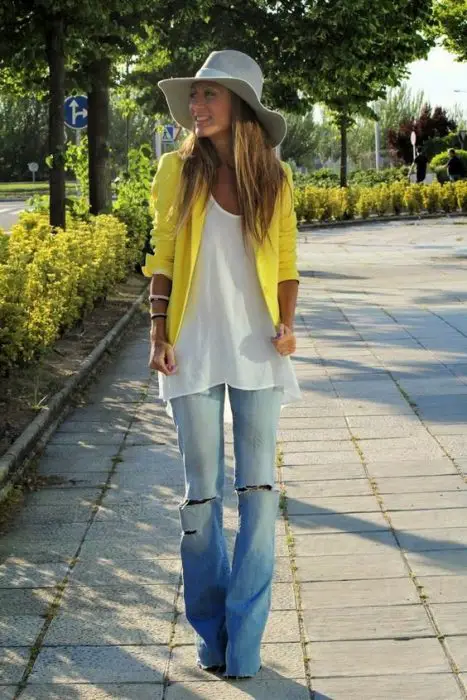 garota de blusa branca, suéter amarelo e jeans rasgado