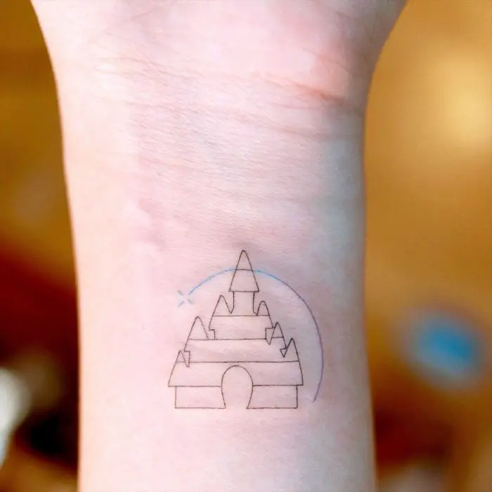 Tatuagem minimalista do castelo da Disney no pulso