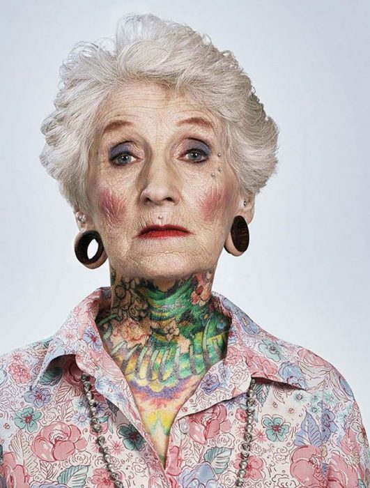 Mulher com tatuagens de idade avançada e expansões nas orelhas 